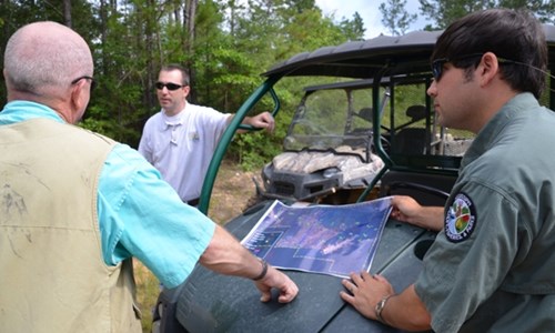 Private Lands Biologist reviews a map with landowners