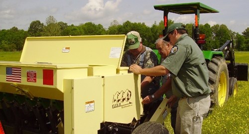 A Private Lands Biologist assists a landowner planting native warm-season grasses