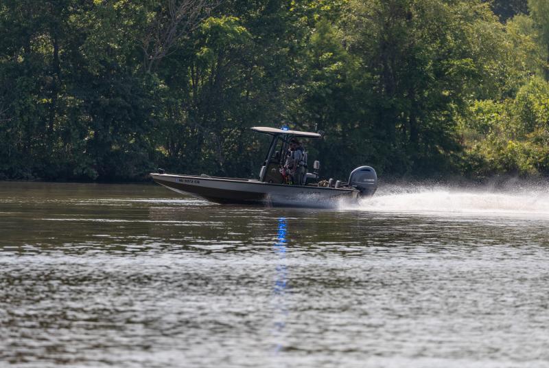 A bright day showing a speedboat driven by conservation officers