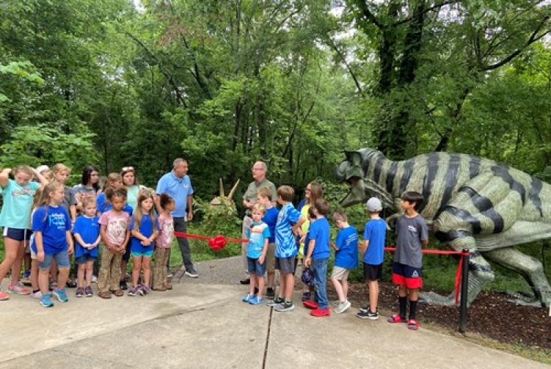 Class of children standing in front of dino exhibit